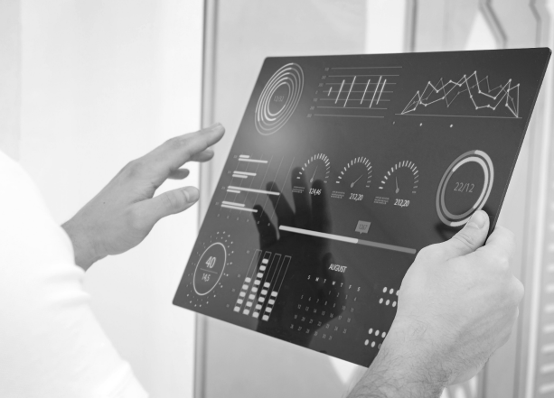 A man displays a black and white photograph featuring a computer screen in his hands