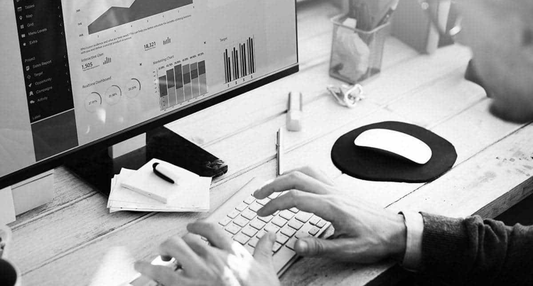 A person focused on typing on a computer keyboard, with hands positioned over the keys.